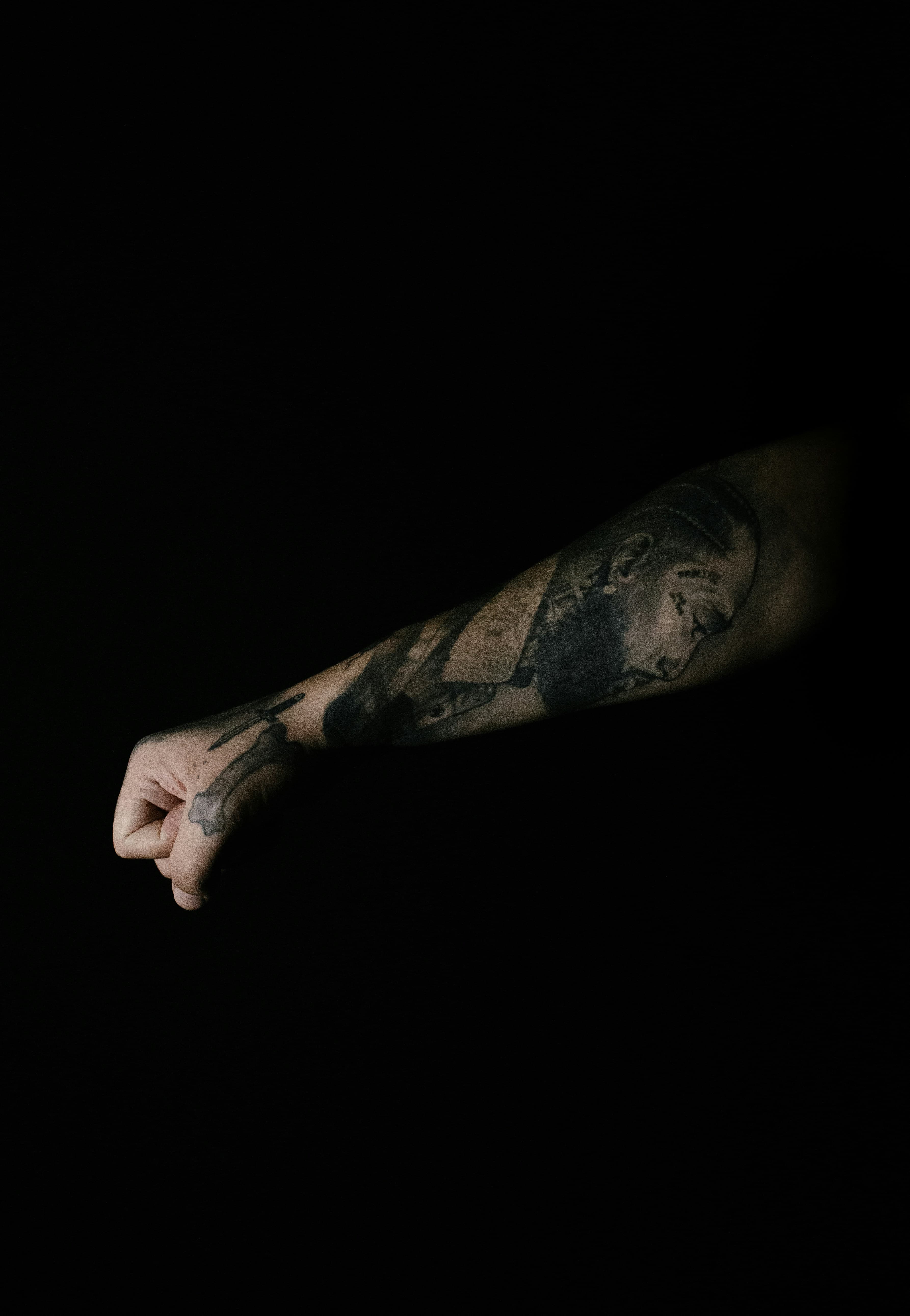 Tatuaje de retrato en negro sólido cubriendo el antebrazo