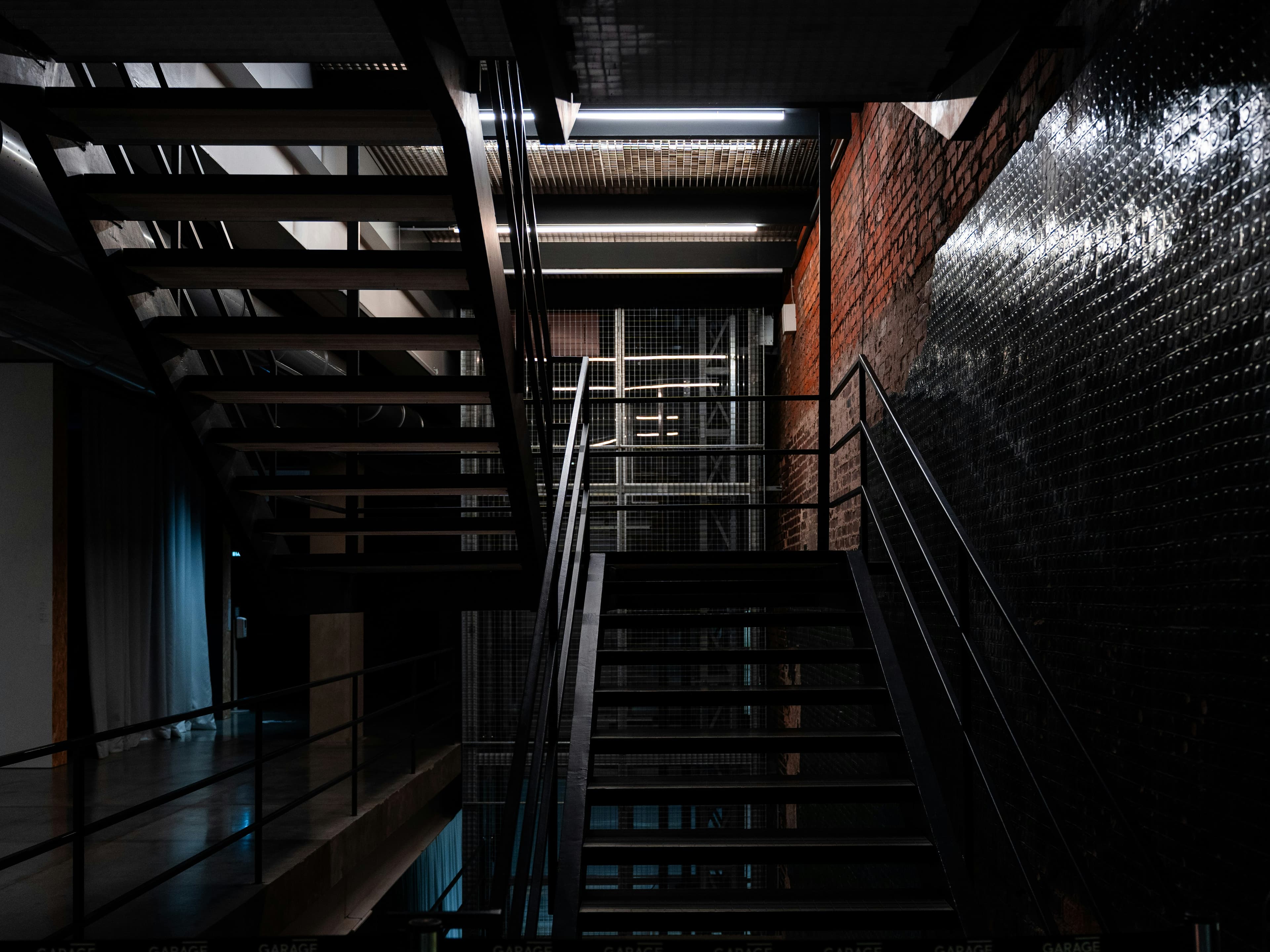 Escalera industrial, ladrillo y baranda metálica