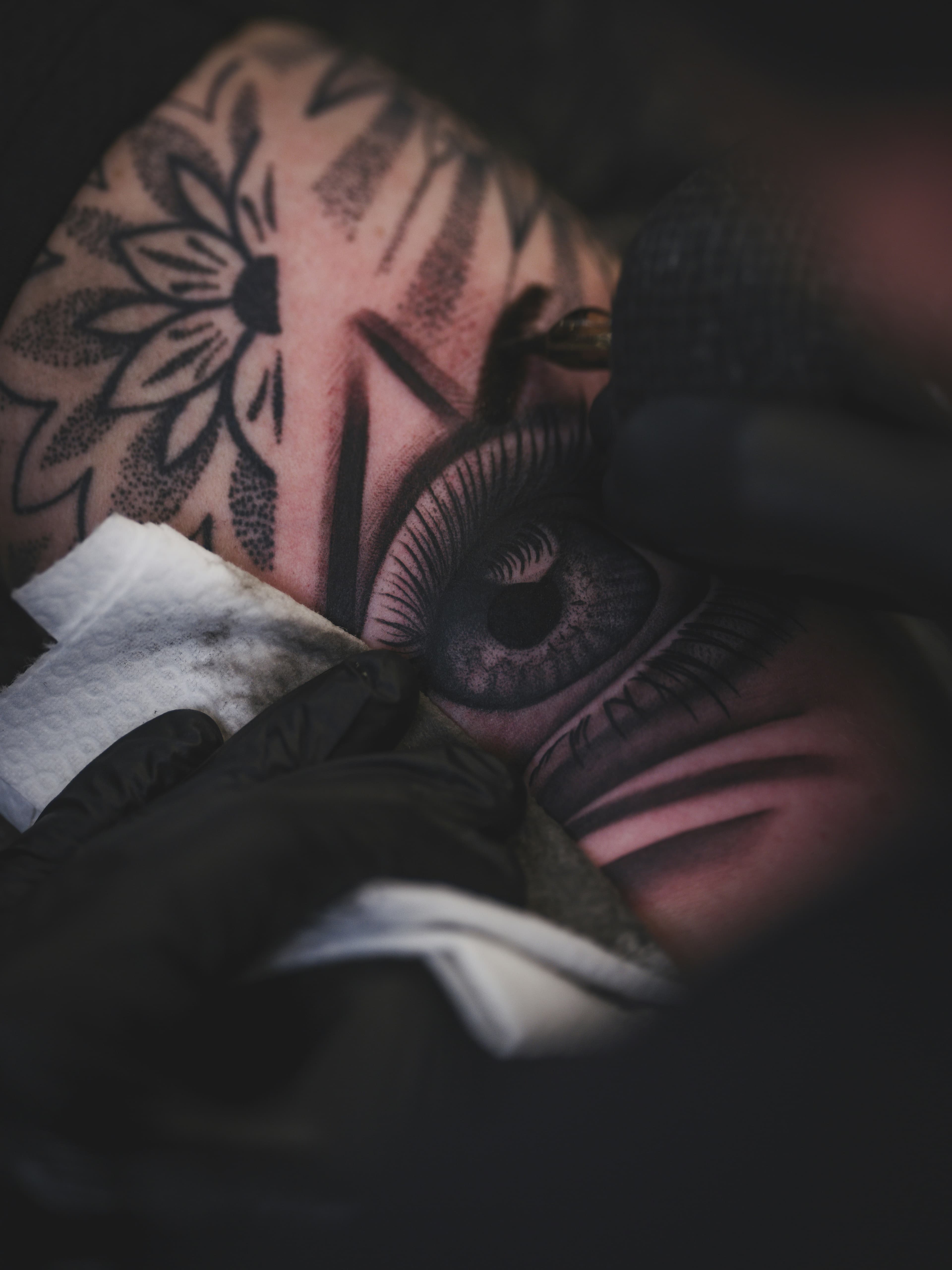 Primerísimo plano de un tatuaje de ojo a mitad de sesión
